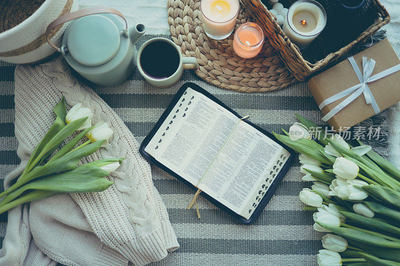 打开圣经，郁金香，毛衣，一杯茶和蜡烛平躺在顶部视图