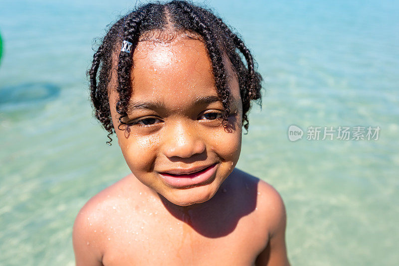 非洲小男孩在热带海滩上玩海的暑假照片。