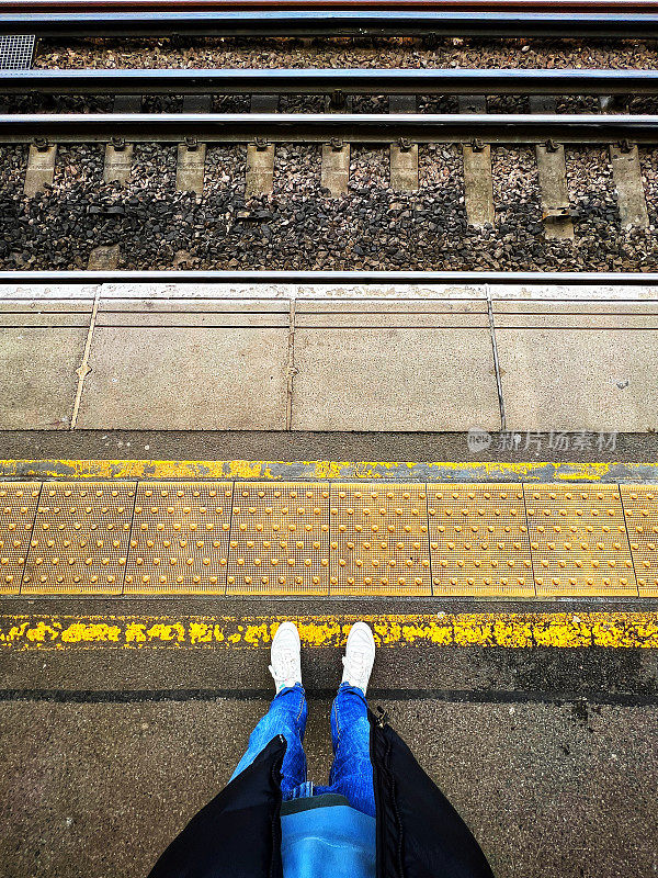 站在火车站站台黄线后面