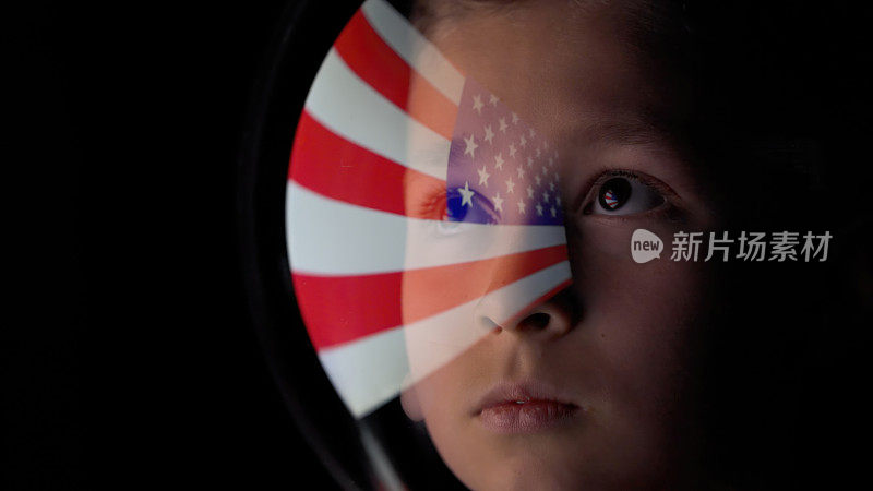 美国国旗映在男孩的太空头盔上