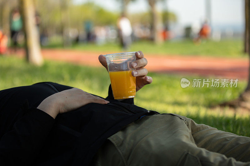 年轻人拿着一个塑料杯。