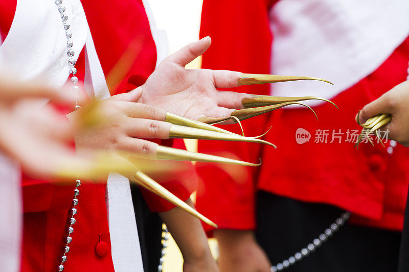 在清迈省，穿着红色衣服的十几岁的泰国朗姆酒舞者张开金色指甲