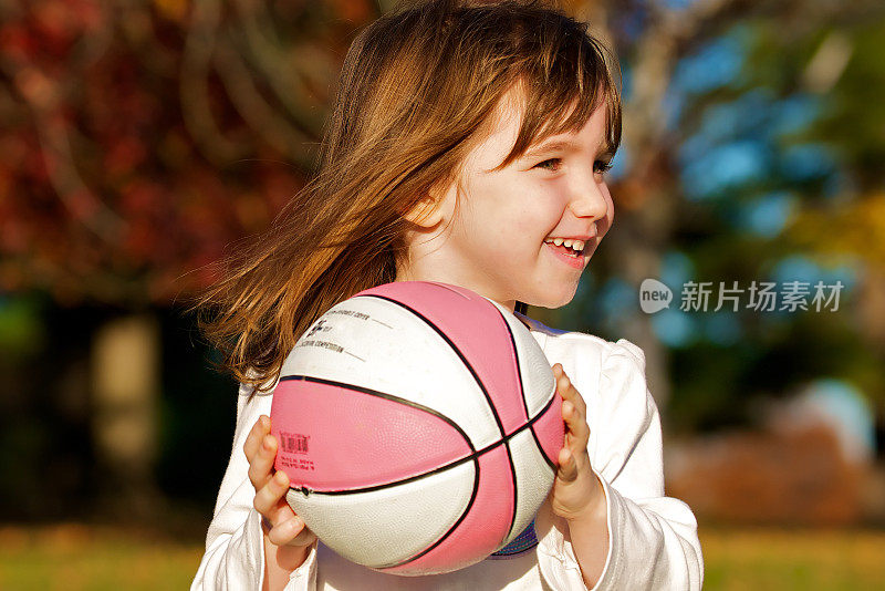 小女孩在秋天打篮球