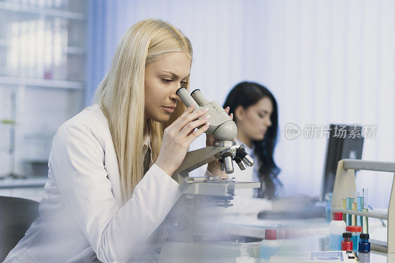 女性科学家在实验室中使用显微镜