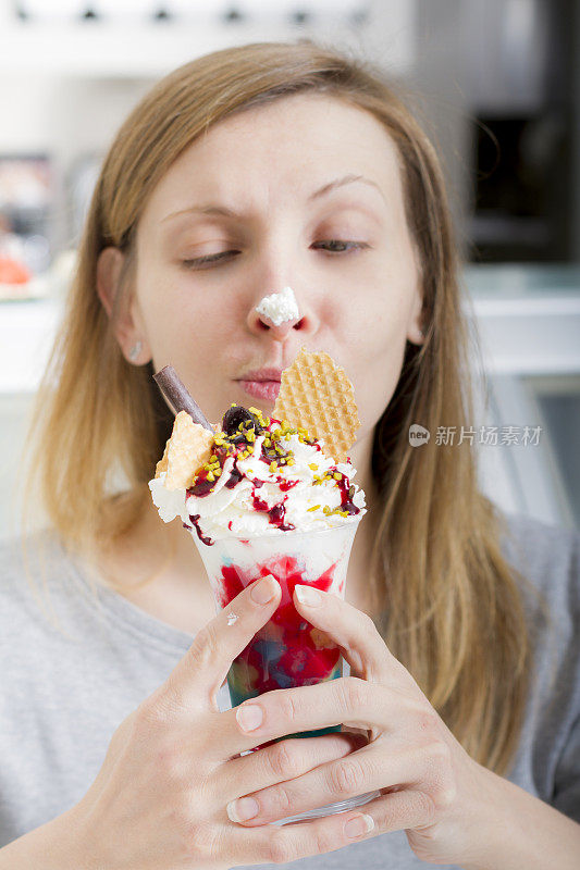 年轻女子品尝着一杯冰淇淋