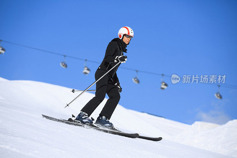 冬季运动女子滑雪者在阳光明媚的滑雪胜地滑雪