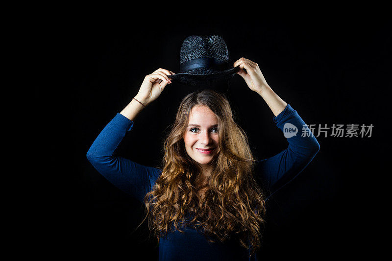 一头棕色卷发的女人戴着黑色的帽子