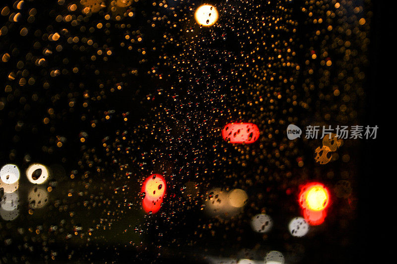 城市街道的野花。雨夜,雨滴。汽车尾灯。挡风玻璃。