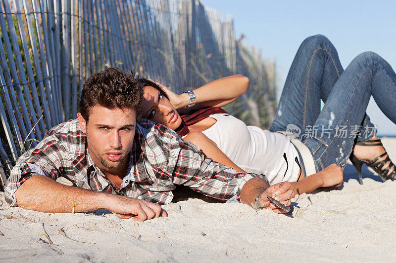 一对性感的情侣躺在沙滩上