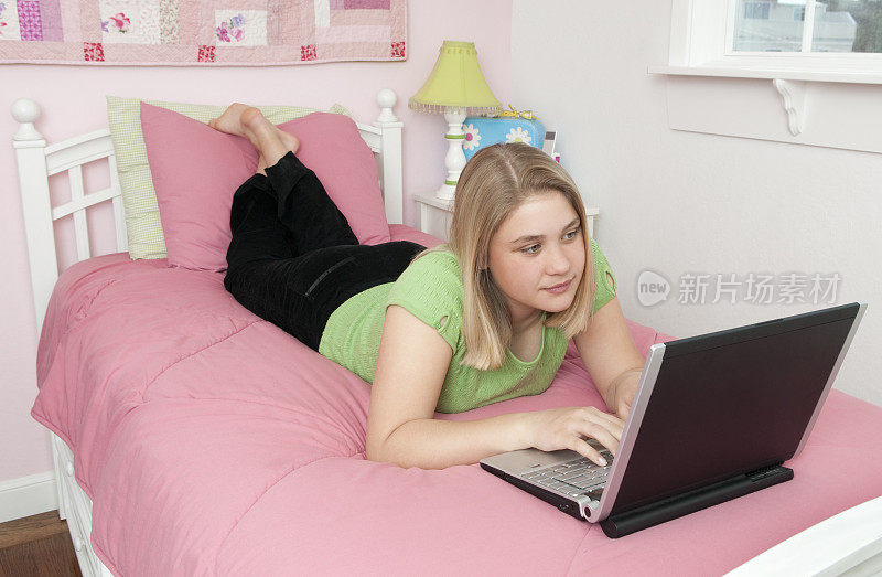 女孩躺在床上使用笔记本电脑