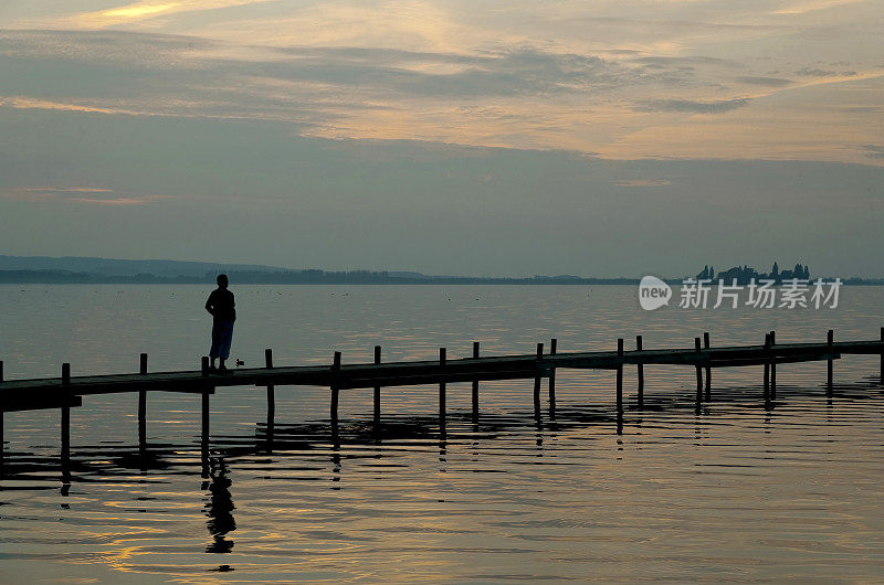 男子站在湖边码头上看日落云景(XXL)