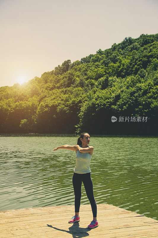 女人在湖边伸展身体