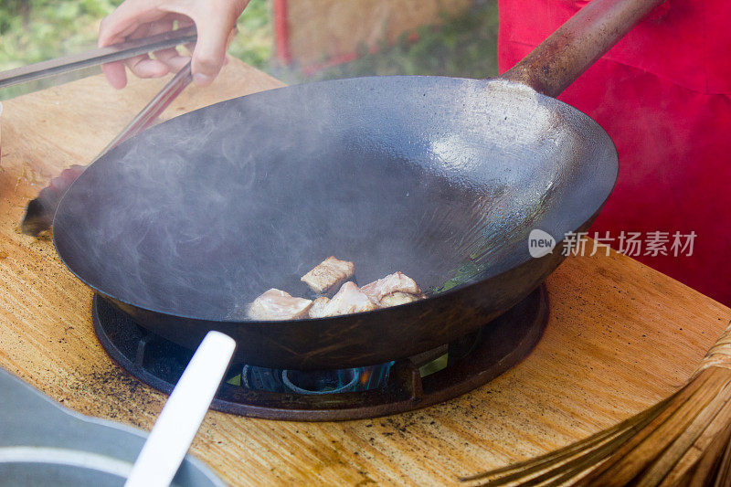 传统的中国食物-炒锅在明火上烹饪。