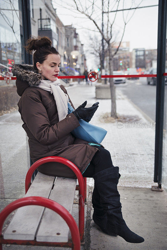 一名女子在公交车站候车。