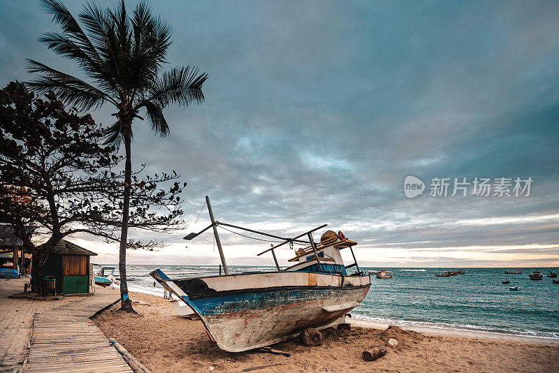 日落时分，一艘渔船在普拉亚多福特海滩的沙滩上