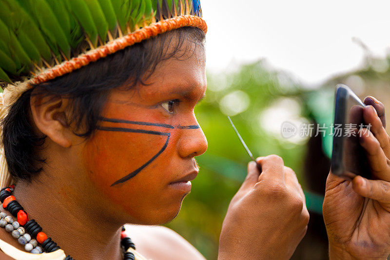 图皮瓜拉尼部落的巴西土著男子在脸上作画，巴西(印第奥)