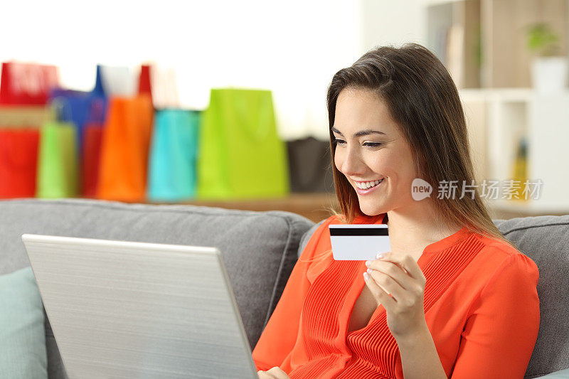 笑容满面的女人用信用卡在网上付款