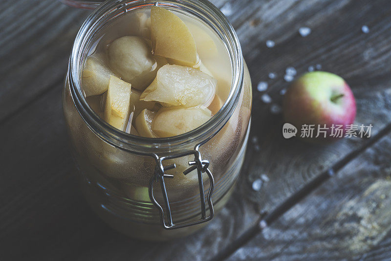 苹果醋在铰链盖罐子在乡村背景