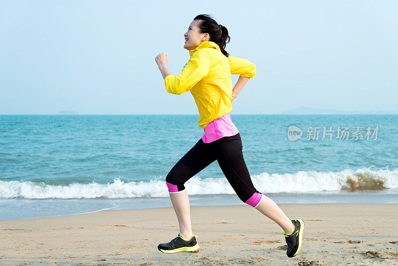 年轻女子在沙滩上跑步