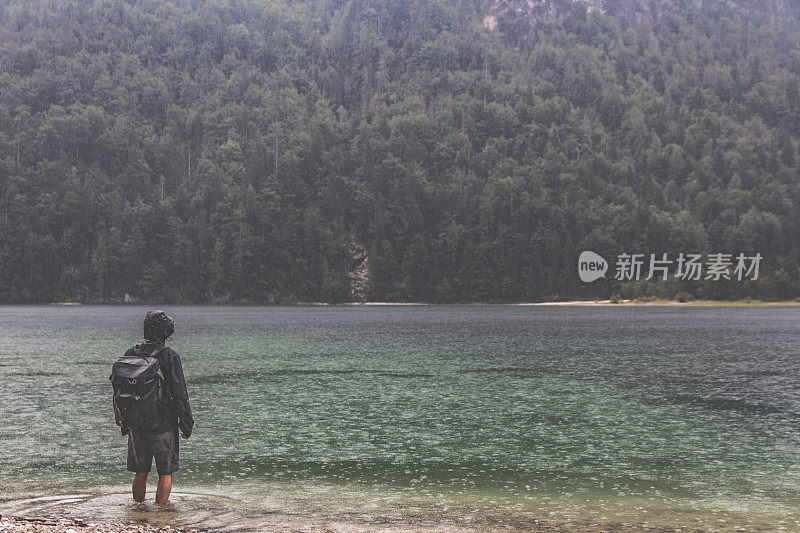 一个人站在雨中的水里