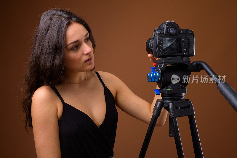 年轻美丽的法国女人在彩色背景下准备拍视频