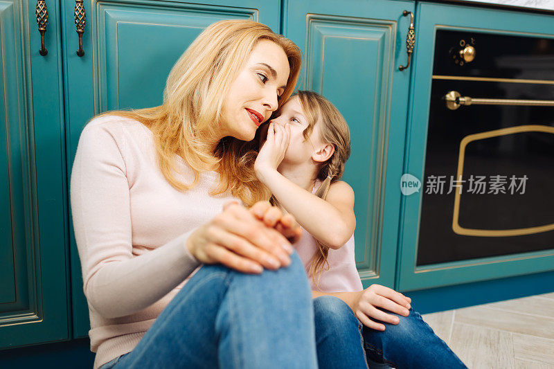 兴高采烈的女儿在她母亲耳边低语