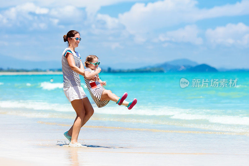 母亲和孩子在热带海滩上。海上度假