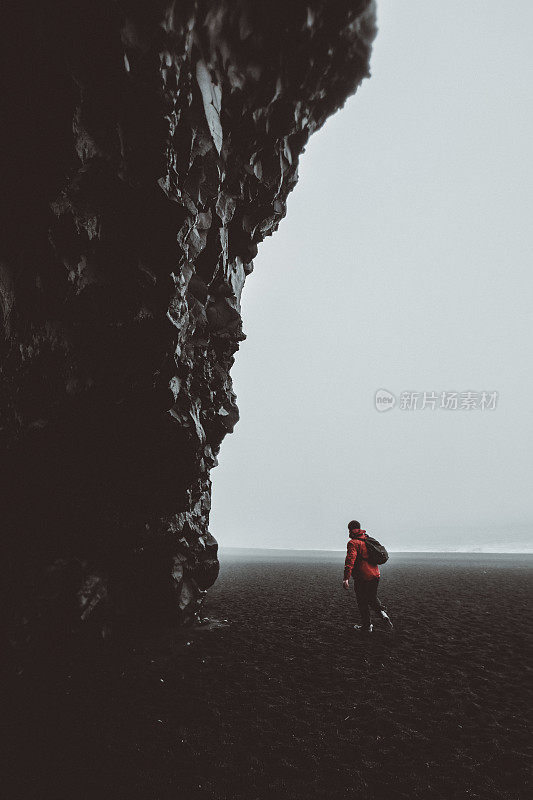 冰岛黑沙滩玄武岩洞穴中男子的剪影