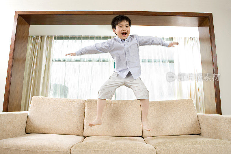 小男孩在沙发上跳跃