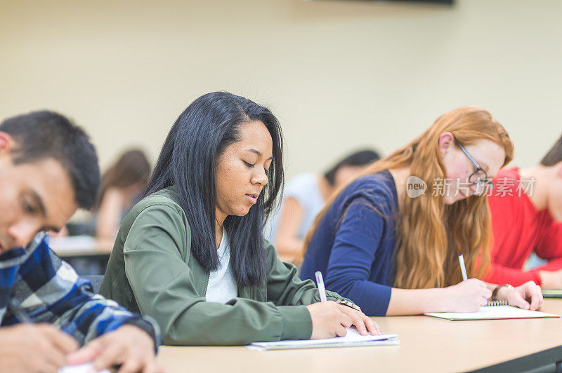 大学生在报告厅的课桌前学习