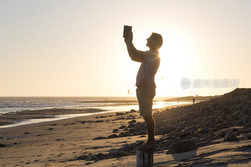男子在海上用数码平板电脑拍照