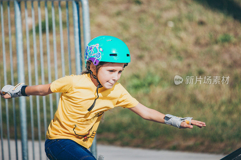 年轻女孩骑滑板公园与安全设备