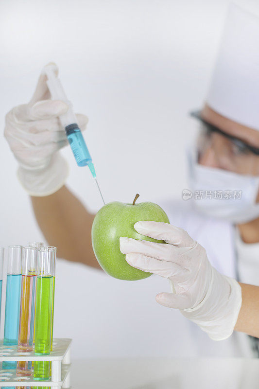 青苹果注射器。转基因食品概念。