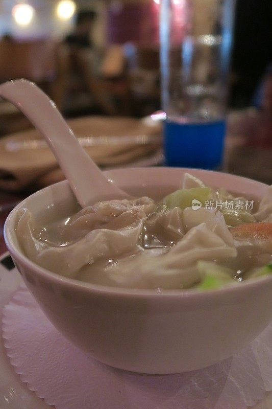 中餐馆里的鸡肉馄饨的图片，配菜勺子，中国饺子碗和东方亚洲蔬菜汤的照片