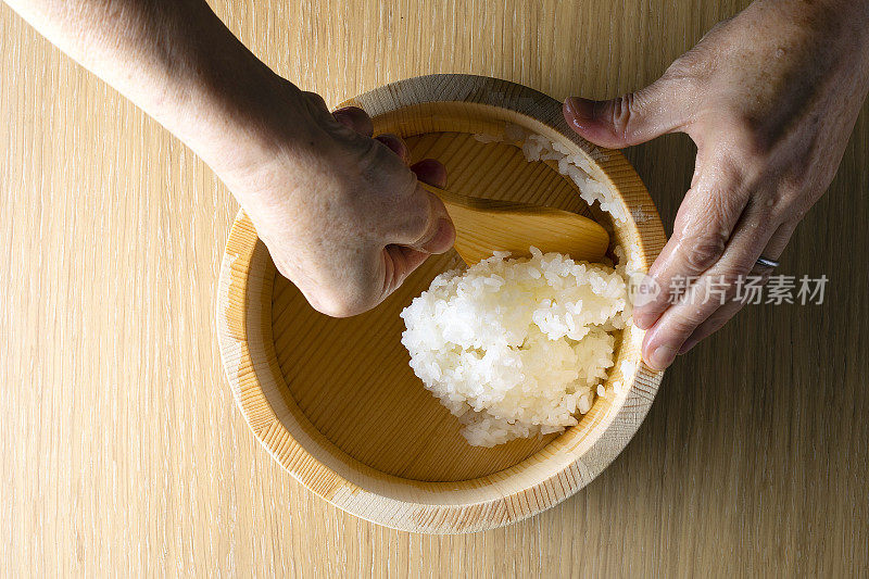 日本老妇人捧着饭团煮米饭