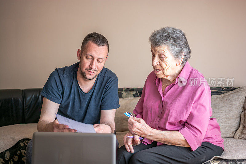 成年的孙子帮助祖母使用电脑