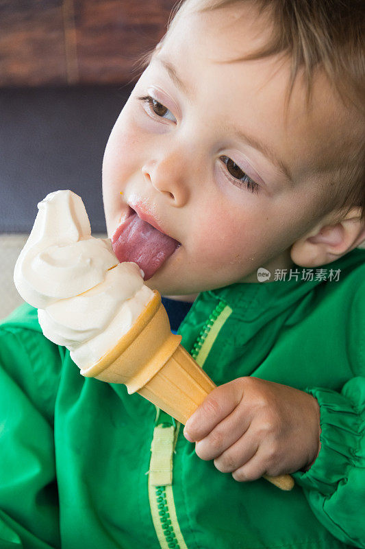 微笑的三岁的孩子，他的舌头在吃冰淇淋