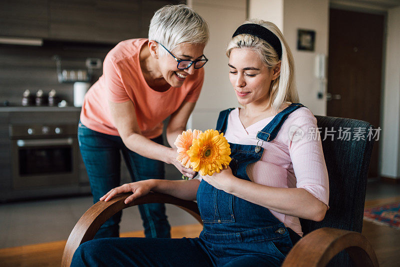 快乐的女人给怀孕的年轻女人送花