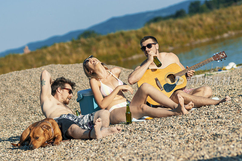 一群快乐的年轻人一起坐在海滩上