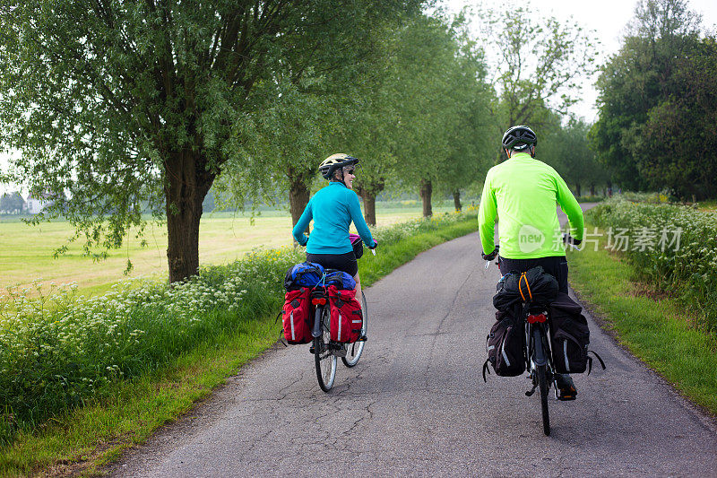 积极的资深自行车手与头盔，背带，齿轮在乡村车道