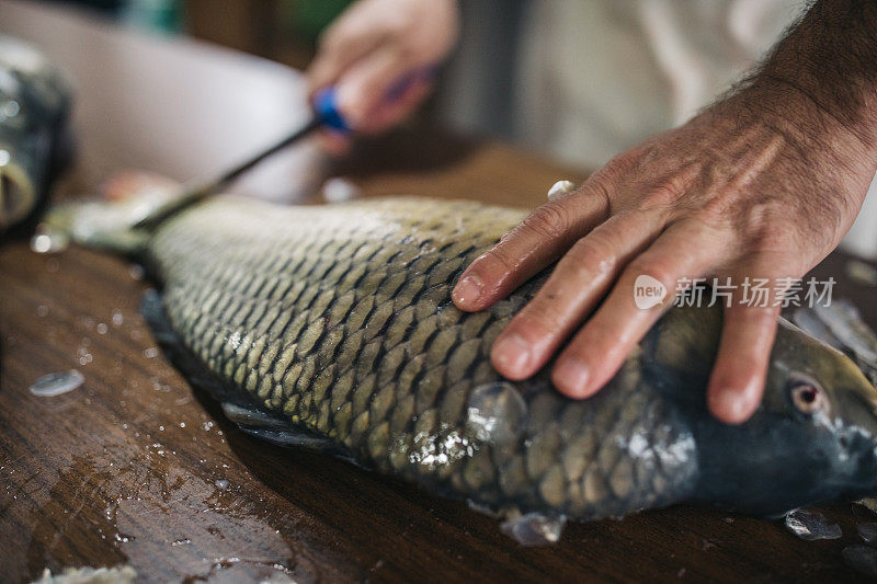 男子在家里的厨房里准备鲤鱼河鱼烹饪健康饮食食品