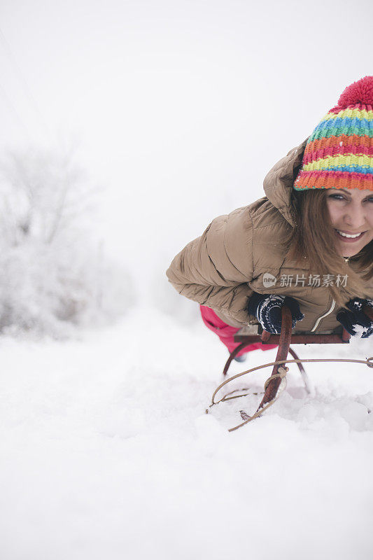 年轻女子在深雪中玩雪橇