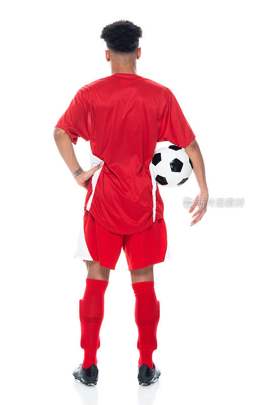 z一代男运动员穿着足球制服站在白色背景前，手持足球进行足球运动和使用运动球