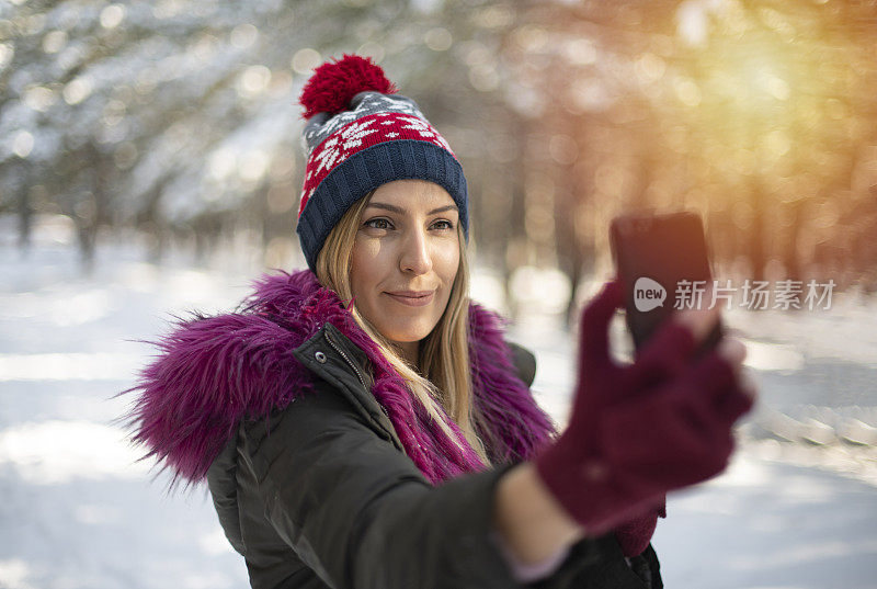 可爱的女人在雪域森林里自拍