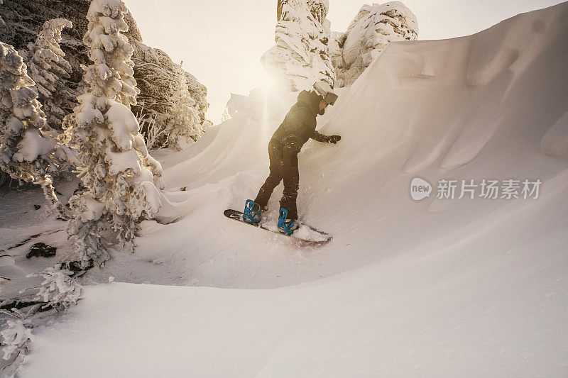 滑雪板女骑在雪上在陡峭的斜坡上看起来像一个海浪冲浪，冬天的一天，白雪覆盖的树木，美丽的悬崖，免费在滑雪胜地