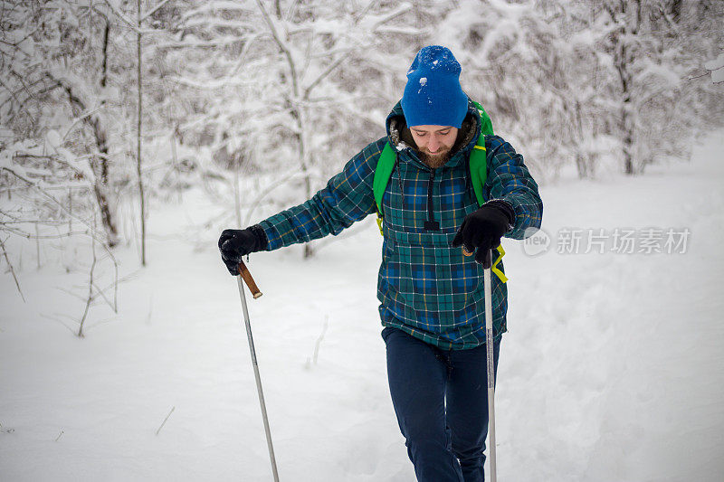 年轻英俊的男子在滑雪运动服山和看别处