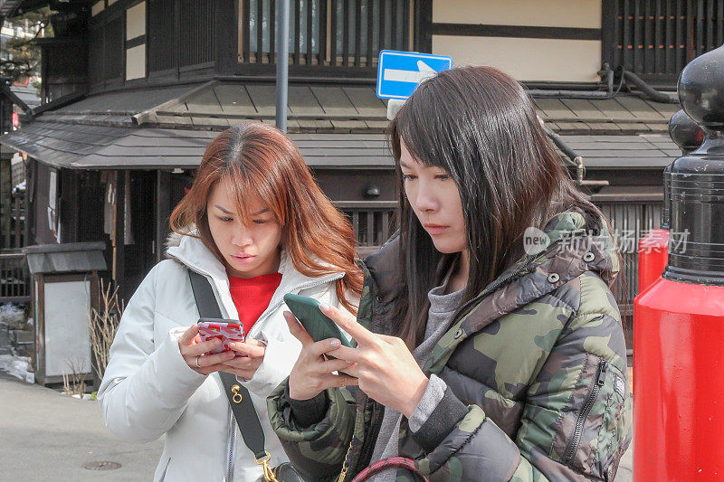 两个亚洲女孩在打电话