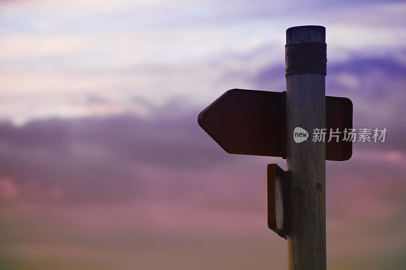 步道路标，云景日落背景。