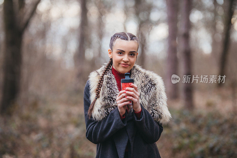 一个年轻漂亮的女人拿着热水瓶的肖像