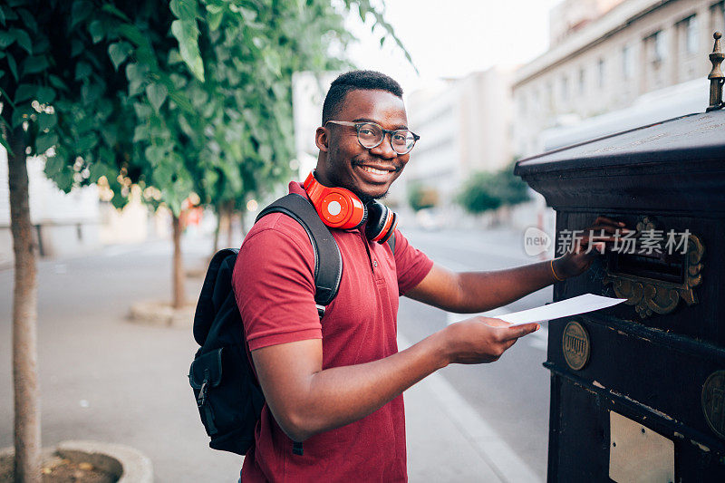 一个快乐的年轻非洲裔美国人通过邮件投票的肖像
